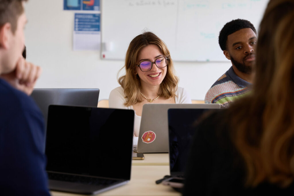 étudiants souriants devant un ordinateur